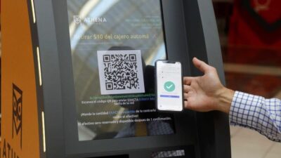 یک نفر در حال اسکن کردن qr کد دستگاه خودپرداز بیت کوین با گوشی موبایل