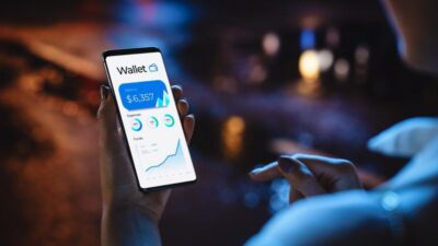 یک مرد در حال کار کردن با نرم افزار کیف پول کریپتو در گوشی موبایل خود